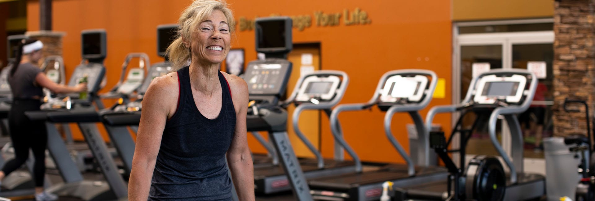 woman smiling near treadmills in a modern gym